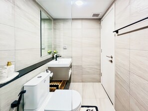 A modern bathroom with a white sink, a toilet, and a mirror. - Modern New 1 BR Condo(BWC2) (Hua Hin)