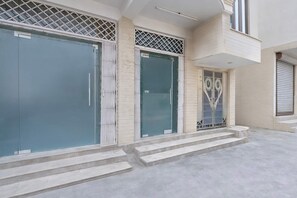 A building with a modern design, featuring a set of double doors, a small balcony, and a set of steps leading to the entrance. - Hotel O Golden Key Rohini (New Delhi)