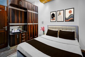 A bedroom with a bed, a wardrobe, and three framed artworks on the wall. - Hotel O Golden Key Rohini (New Delhi)
