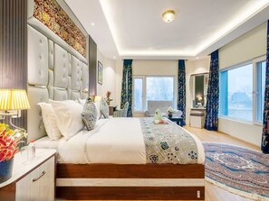 Un dormitorio moderno con una cama grande, una mesita de noche, un escritorio y una silla.