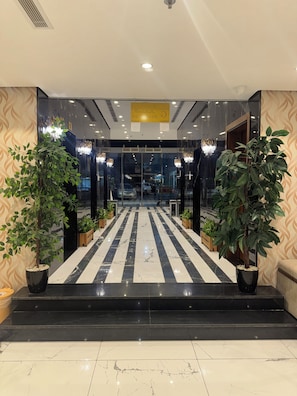 A hotel entrance with a marble floor, potted plants, and a chandelier. - Shaza Asil Hotel (Makkah)