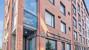 Ein mehrstöckiges Backsteingebäude mit großen Fenstern und einer Schaufensterfront.