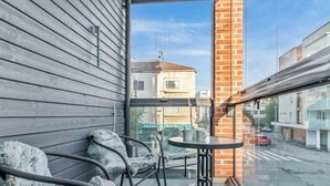 Ein Balkon mit Blick auf eine Straße, einem Tisch und Stühlen.