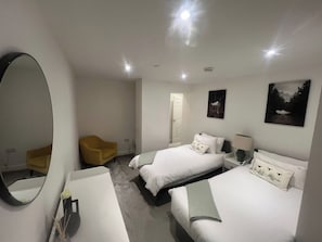 A hotel room with two beds, a large mirror, a chair, and artwork on the walls. - Central Cardiff Sleeps 6  Free Parking (Cardiff)