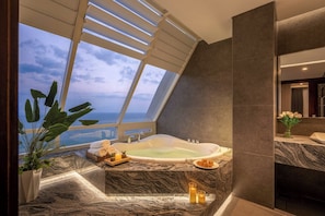 A modern bathroom with a large skylight, a bathtub, and a marble countertop. - Coho penthouse Vung Tau Luxury 3BR Oceanfront, Private Pool & Sauna (Ho Chi Minh City)