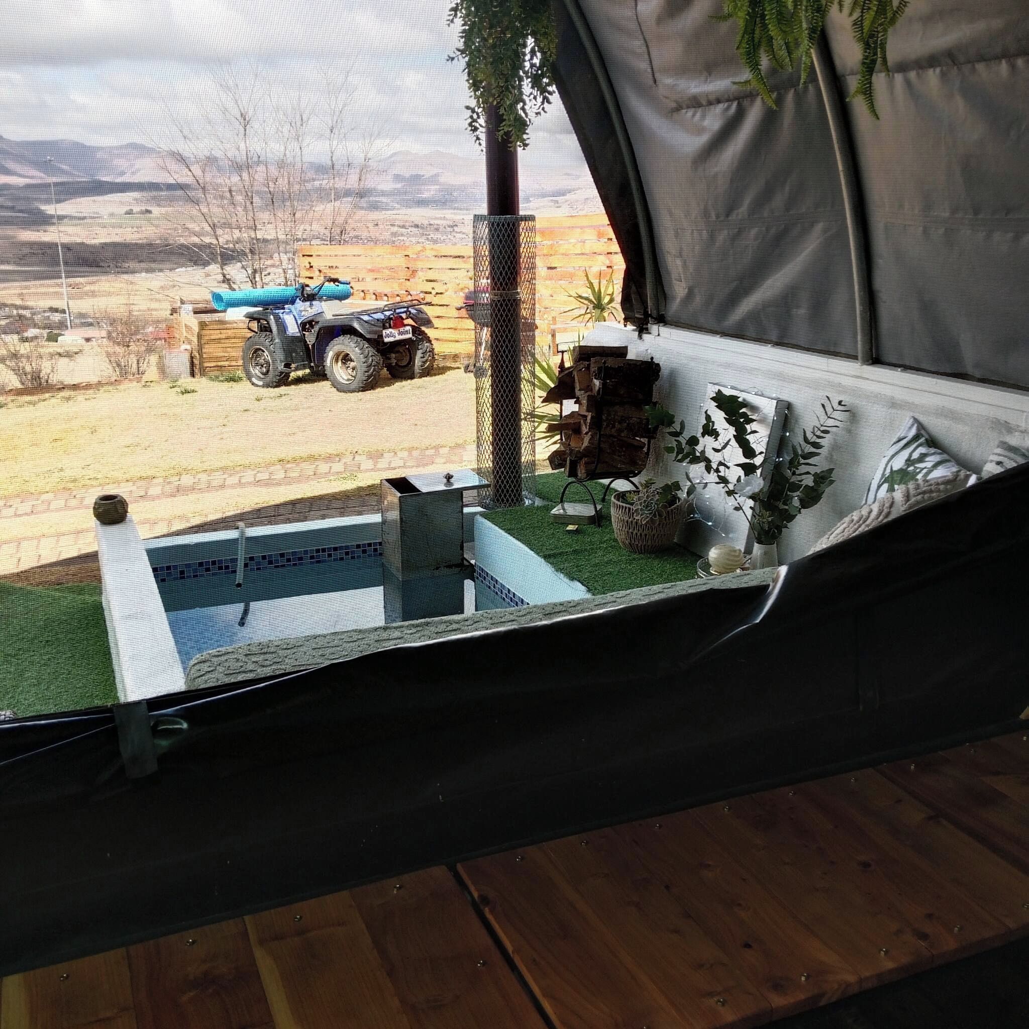 Une tente offrant une vue sur un véhicule et un paysage.