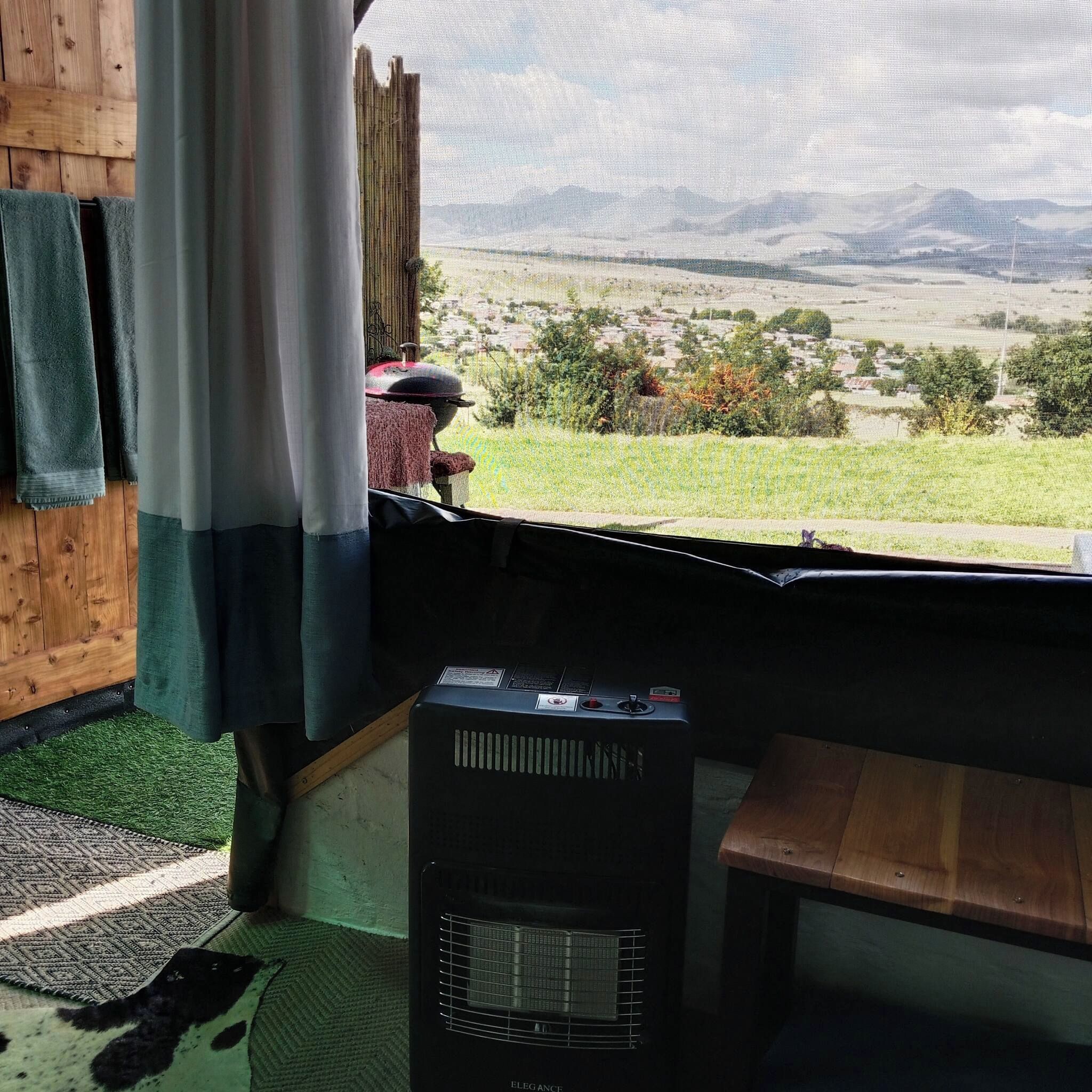 Una habitación con vistas a un paisaje, un calentador y un banco.