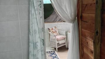 A room with a bed, a chair, and a patterned rug.