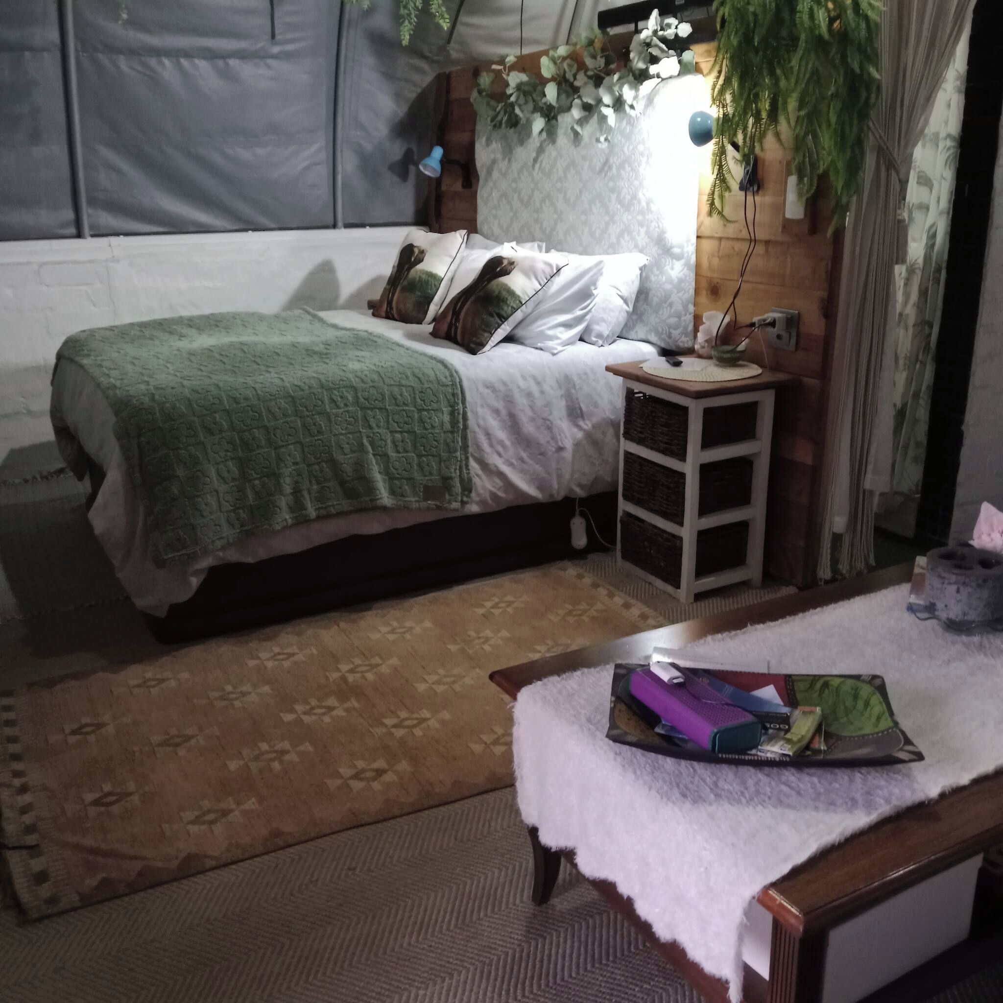 A bedroom with a bed, bedside table, and a small rug.