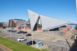 A parking lot with multiple cars and a building with a unique triangular roof.