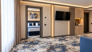 Una habitación de hotel con una cama, televisión, cafetera y sofá.