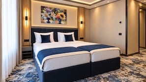 A double bed with a dark headboard, a large painting above, and a patterned carpet. - Hotel Eskada (Iași)