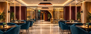 A modern interior with a central corridor leading to a reception area, flanked by seating areas with tables and chairs. - Hotel Eskada (Iași)