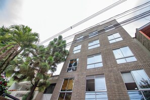 A multi-story building with a brick facade, large windows, and a visible balcony on the second floor. - 21 Studio near the forest and Atanasio (Medellín)