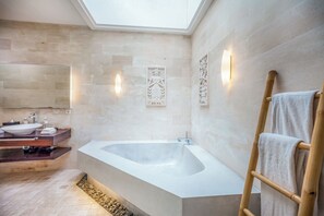 A modern bathroom with a freestanding bathtub, a vanity with a sink, and a skylight. - K Villa Seminyak by Premier Hospitality  (Seminyak)