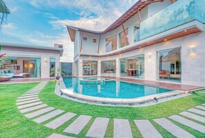 A modern two-story house with a swimming pool, a covered patio, and a well-maintained lawn. - K Villa Seminyak by Premier Hospitality  (Seminyak)