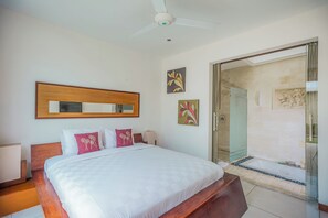 A hotel room with a bed, a ceiling fan, a large mirror, and artwork on the walls. - K Villa Seminyak by Premier Hospitality  (Seminyak)