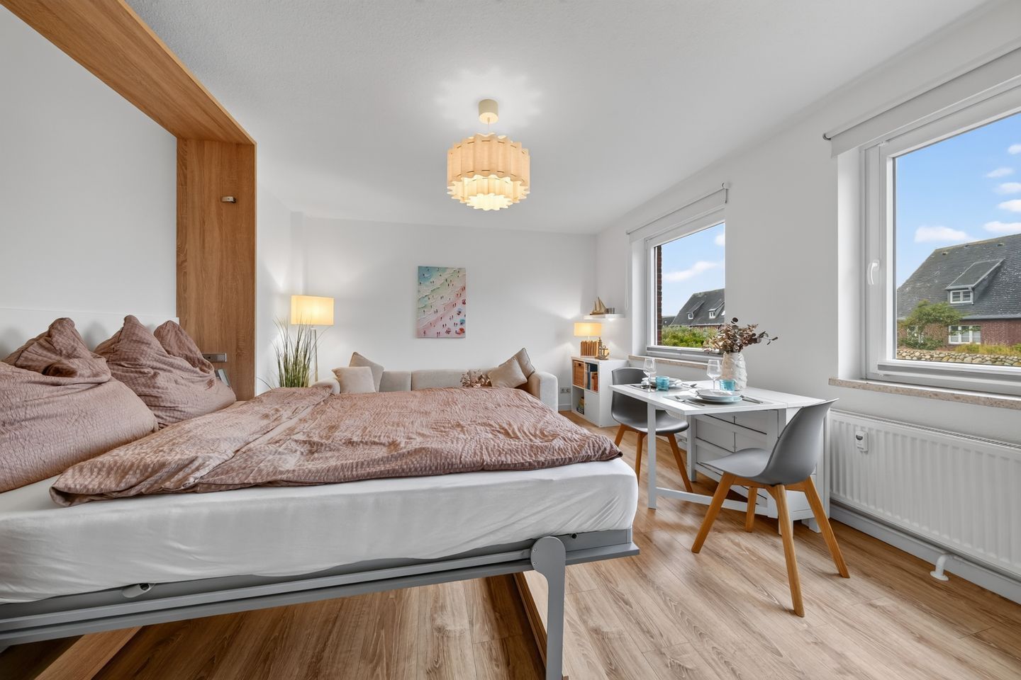 A modern bedroom with a bed, bedside table, desk, and chair.
