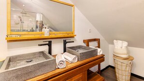 A bathroom with a large mirror, two sinks with modern faucets, and a wooden vanity. - Vrbo Property (Saint-Louis)