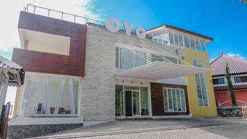 A modern building with a prominent 'OYO' sign, large windows, and a tiled roof.