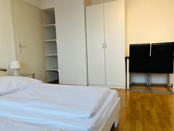 Un dormitorio con cama, armario y zona de estar.