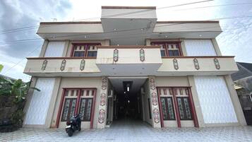 A two-story building with a tiled entrance and a motorcycle parked in front.