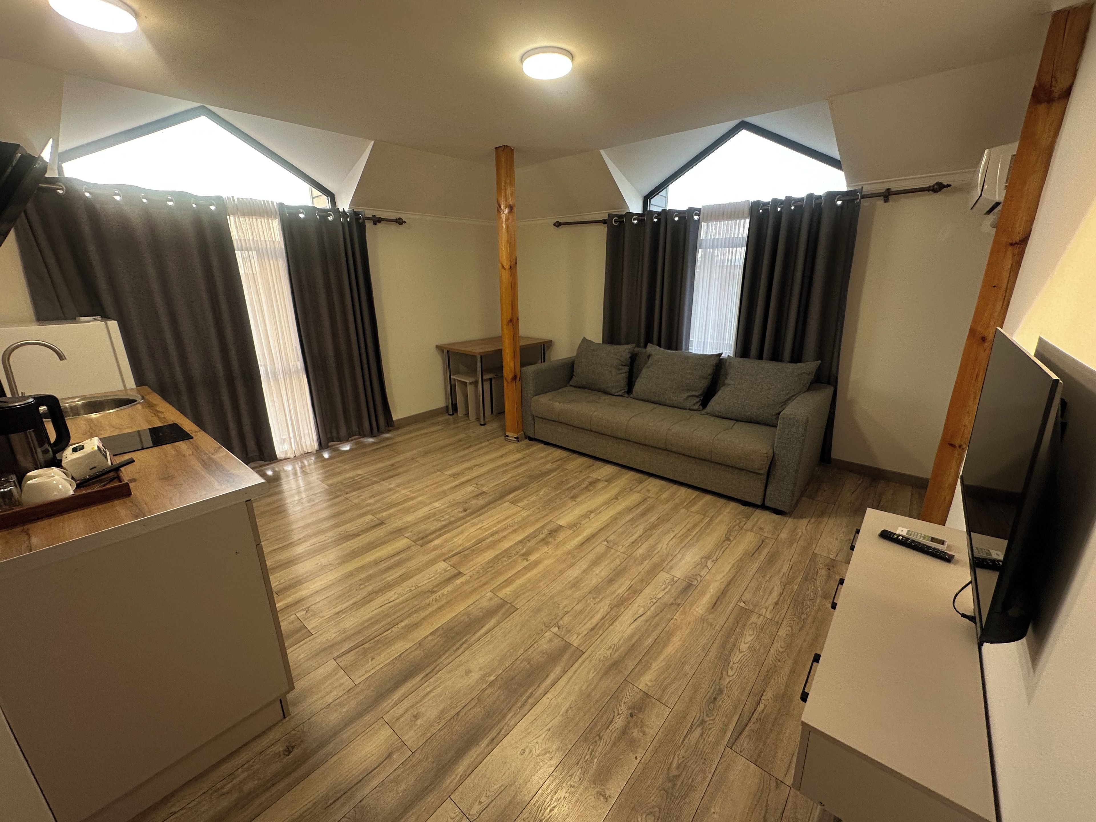 En moderne stue med sofa, sofabord og fjernsyn.