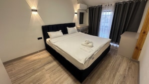 A modern hotel room with a large bed, bedside lamps, a desk, and a window with curtains. - Dream AsiaMall (Bishkek)