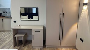 Un dormitorio moderno con cama, mesita de noche, armario y espejo.