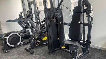 A gym with exercise equipment including a treadmill, a weight machine, and a stationary bike.