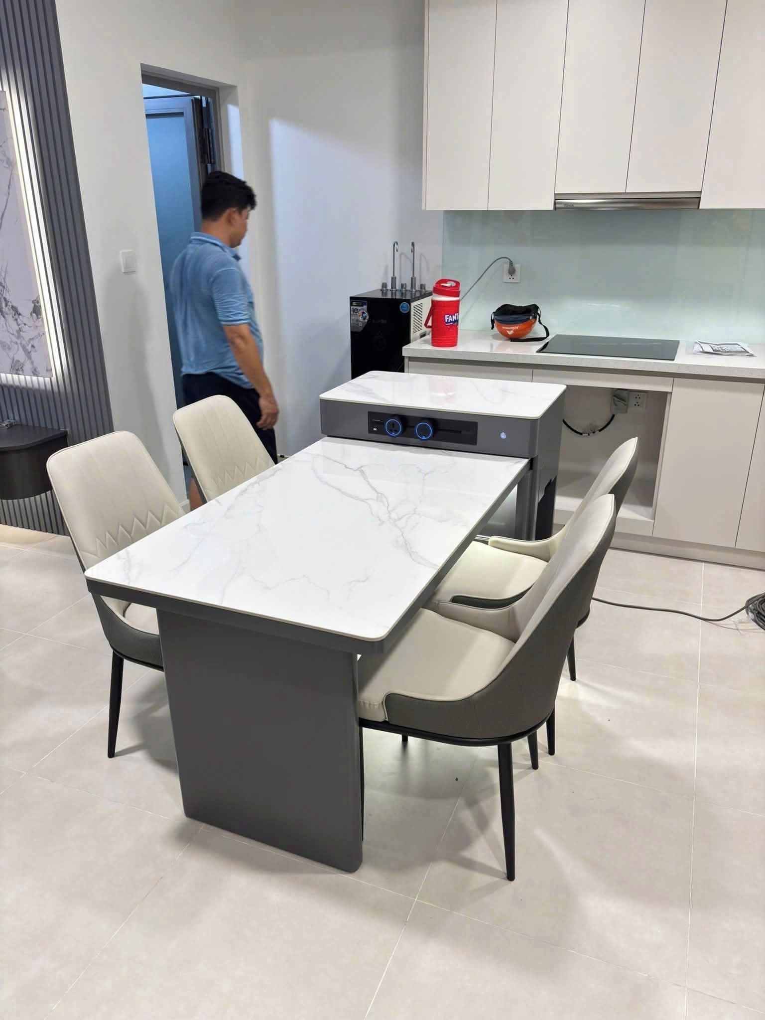 A modern kitchen with white cabinets, a marble countertop, and a built-in stove.
