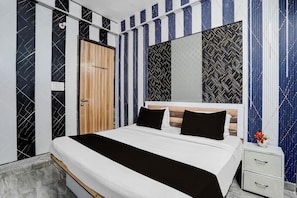A modern bedroom with a bed, bedside tables, and a wardrobe. - Hotel O Sector 121 Gaur City Mall Noida (Noida)