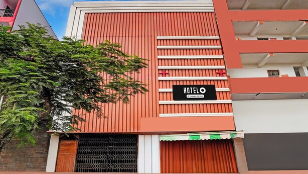 Un hotel con fachada roja, un letrero que indica servicio para empresas y un ventanal visible.
