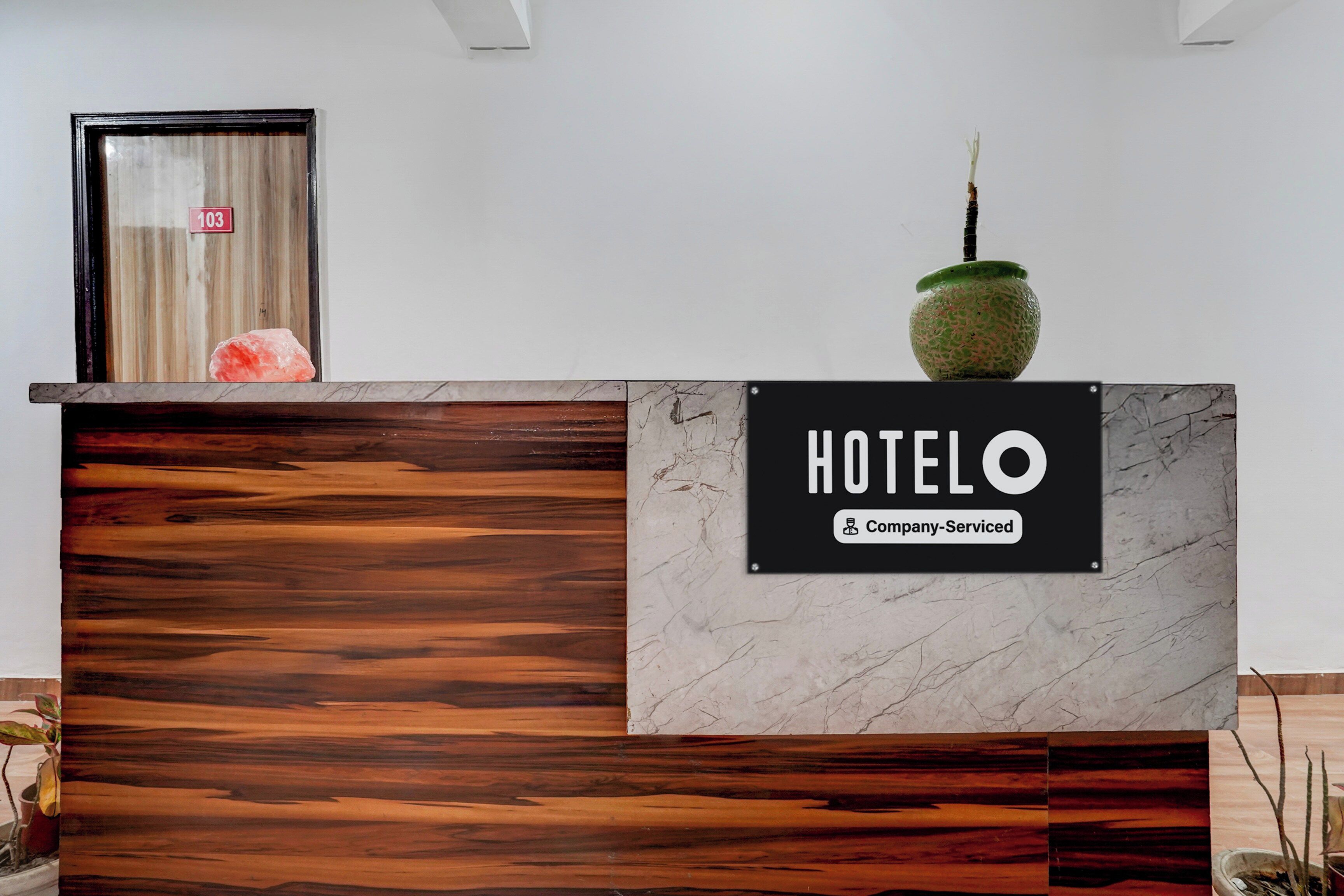 Un mostrador de recepción de hotel con un letrero que dice 'HOTEL' y una etiqueta que indica 'Servicio de Empresa'.