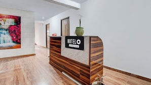 Mostrador de recepción de hotel con un aviso que indica servicio de empresa.