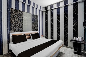 A modern bedroom with a large bed, a wooden headboard, and a black and white striped wall pattern. - Hotel O Sector 121 Gaur City Mall Noida (Noida)