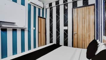 Een hotelkamer met een bed, een kledingkast en een airconditioning.