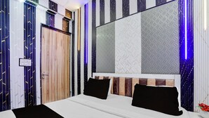 Un dormitorio moderno con una cama grande, un espejo y una pared con diseño.
