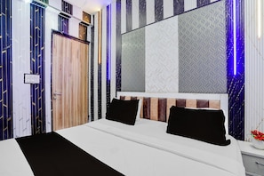 A modern bedroom with a large bed, a mirror, and a patterned wall. - Hotel O Sector 121 Gaur City Mall Noida (Noida)