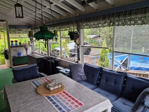 Una habitación acogedora con sofá, una mesa y vistas a un coche y follaje exterior.