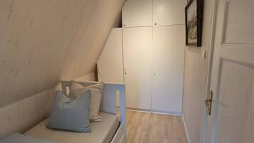 A bedroom with a bed, a wardrobe, and a door.