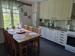 A kitchen with white cabinets, a microwave, a sink, and an oven.