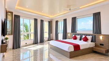 A modern hotel room with a large bed, a flat-screen TV, and a view of the outdoors.