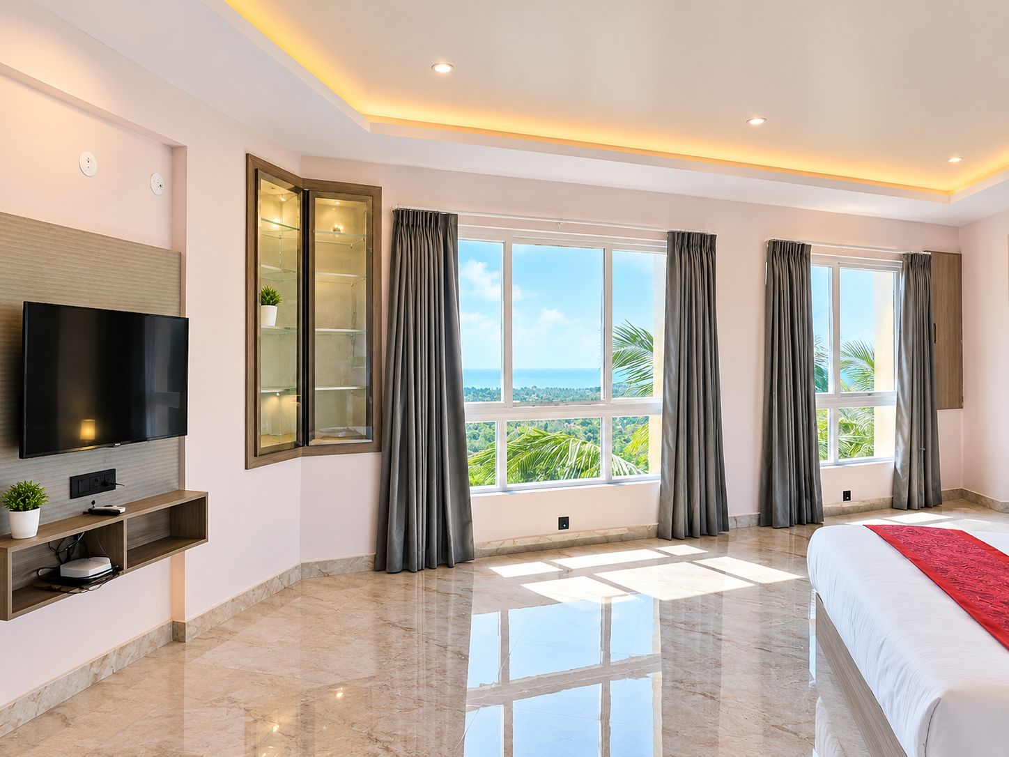 Een moderne hotelkamer met een groot bed, een flatscreen televisie, een inbouwkast en uitzicht op de oceaan.