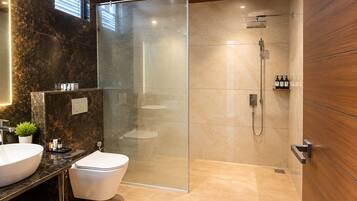 A modern bathroom with a glass-enclosed shower, a white toilet, and a marble vanity.