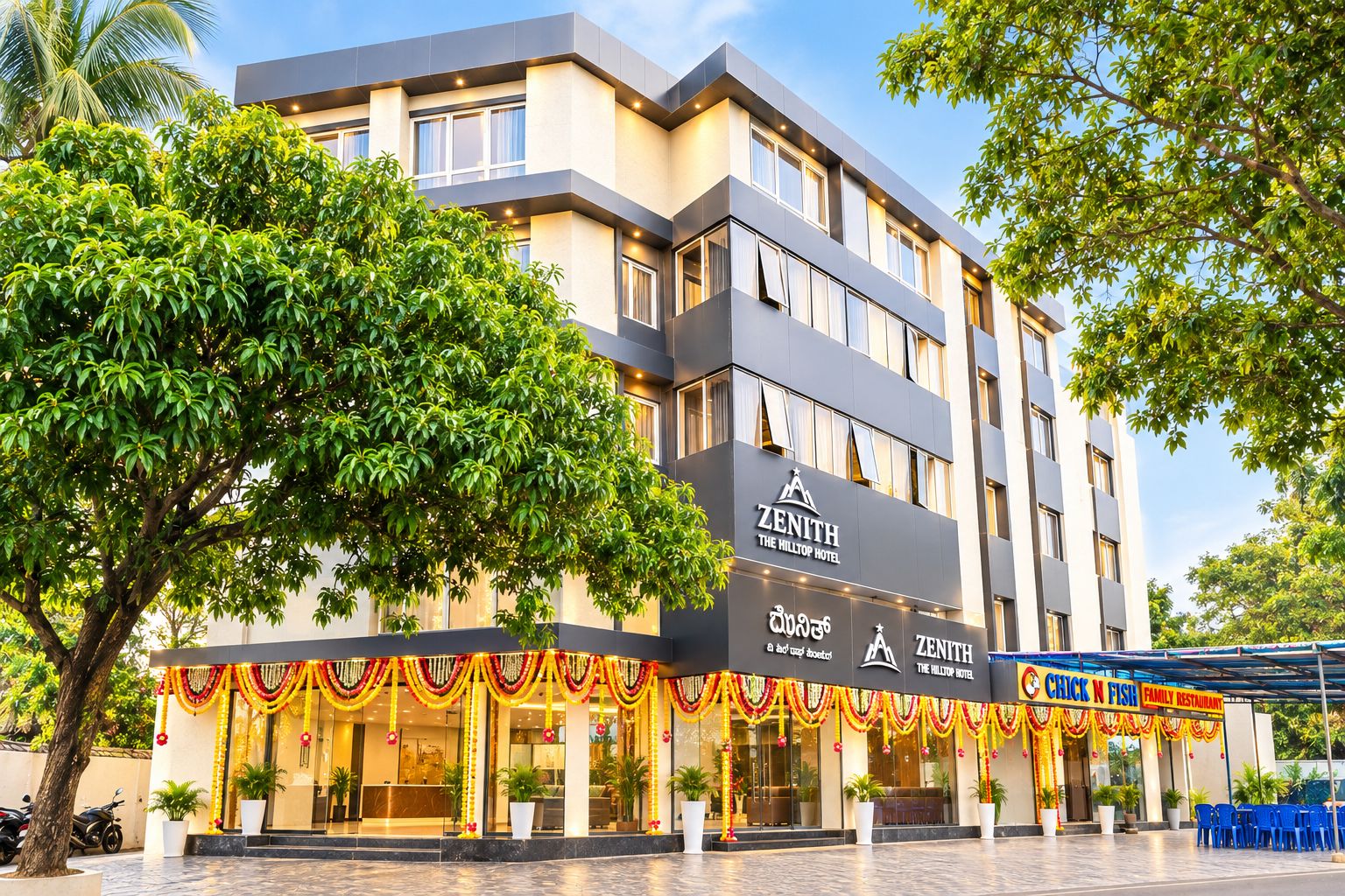 A multi-story hotel with a modern facade, a visible restaurant named 'Chuck N Fish Family Restaurant,' and a well-maintained outdoor area with potted plants.