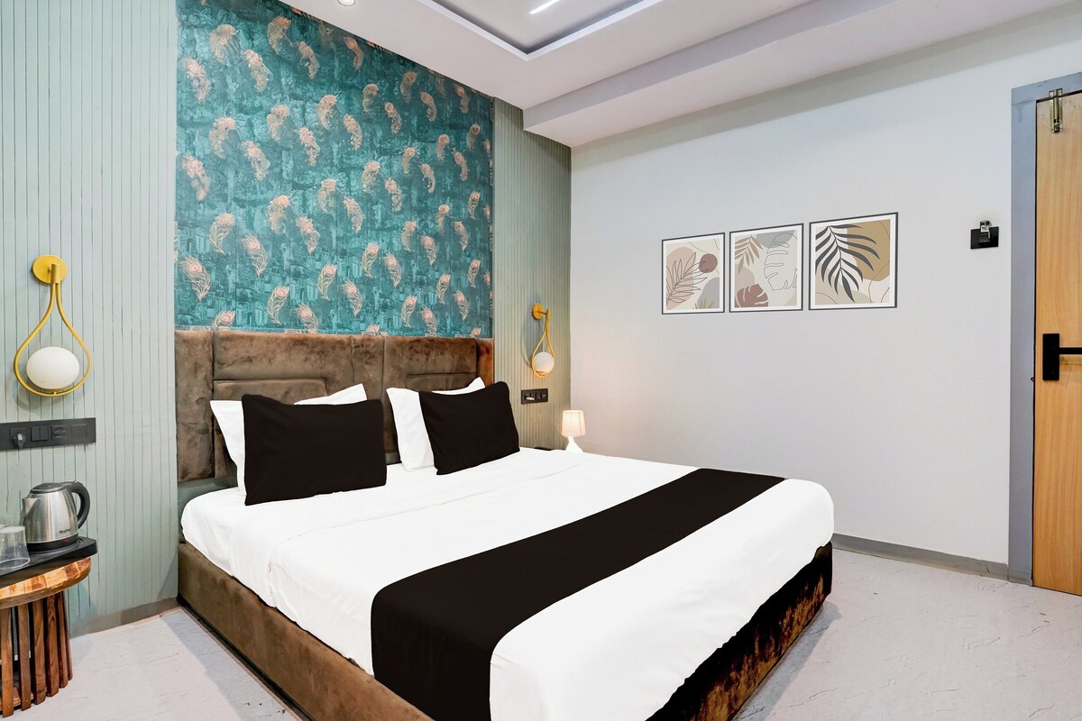 A modern bedroom with a bed, bedside tables, a kettle, and wall art.