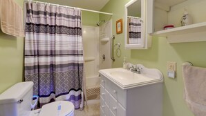 A bathroom with a shower, toilet, sink, and a mirror above the sink. - Private Beach Access! Lake Champlain Cabin (Plattsburgh)