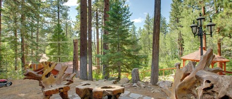 A forested area with wooden benches and a rustic gazebo.