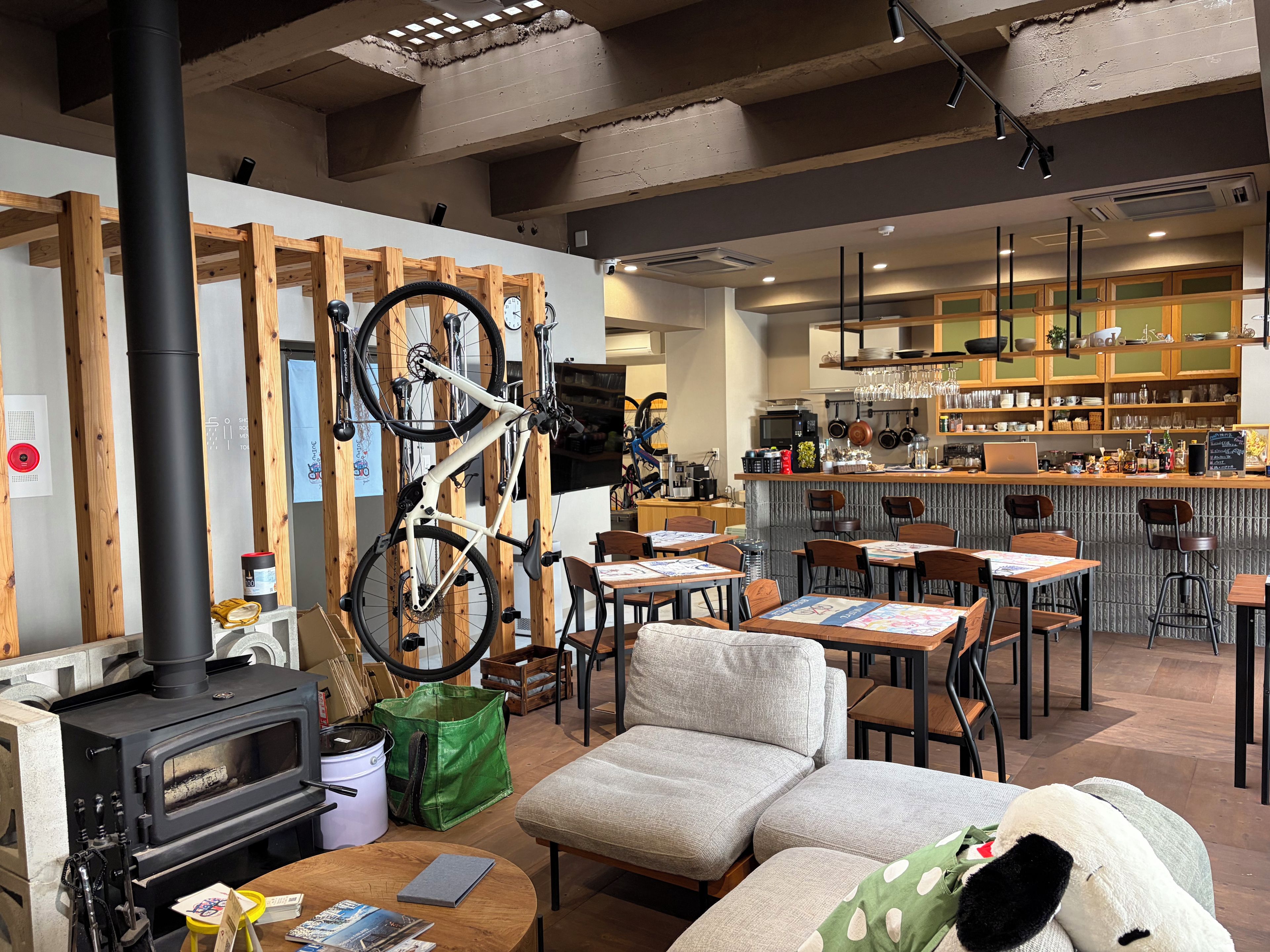 Un interior acogedor con chimenea de leña, zona de estar y barra con cocina al fondo.